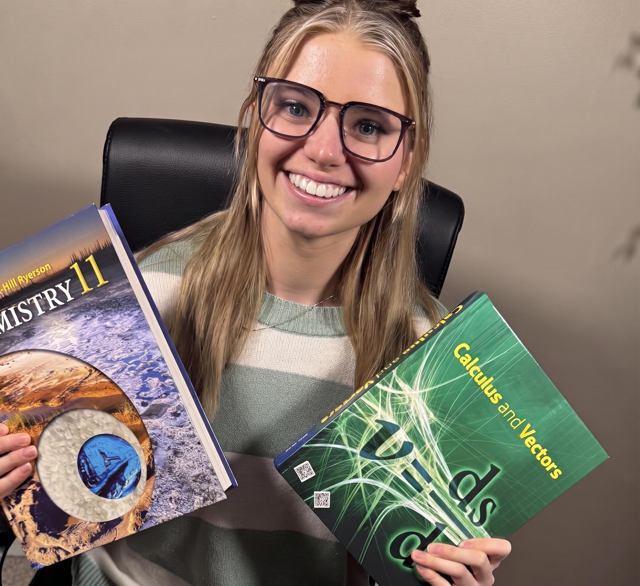 Liv smiling and holding math and science textbooks